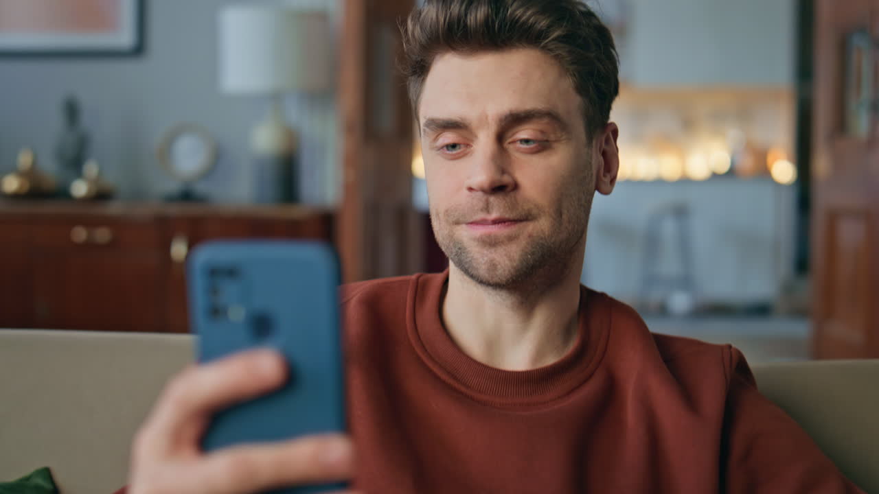 Businessman greeting video call by smartphone sitting home close up. Man swiping