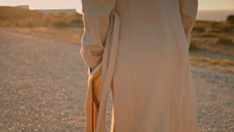 piernas hipster yendo por la carretera en un primer plano junto al mar. mujer pacífica caminando a la luz del sol