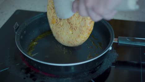 Flipping-a-potato-omelette-in-a-frying-pan-while-it's-cooking