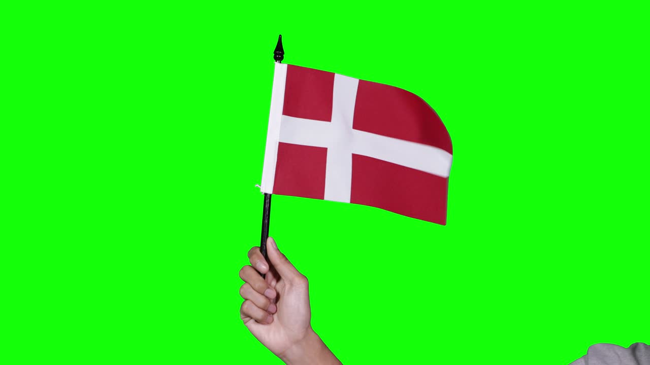 Ukendt hånd holder et viftende Dannebrog.