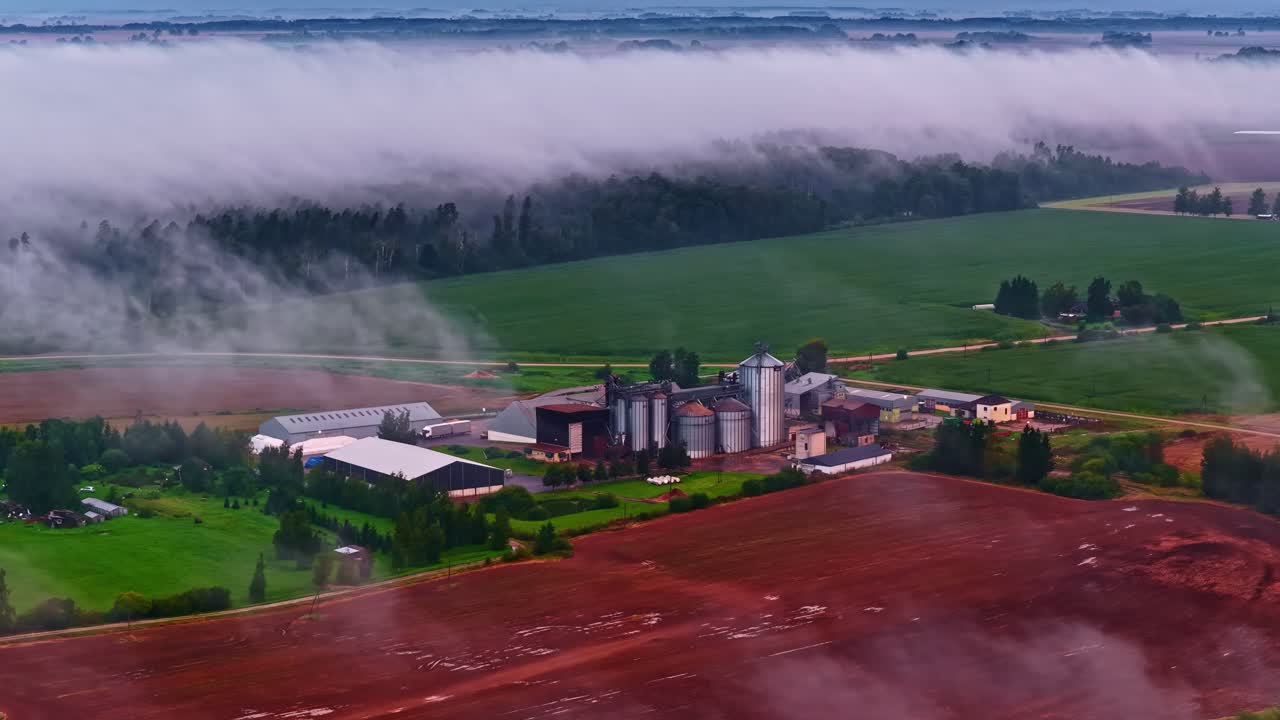 Factory industrial building complex surrounded by farmland layer of fog