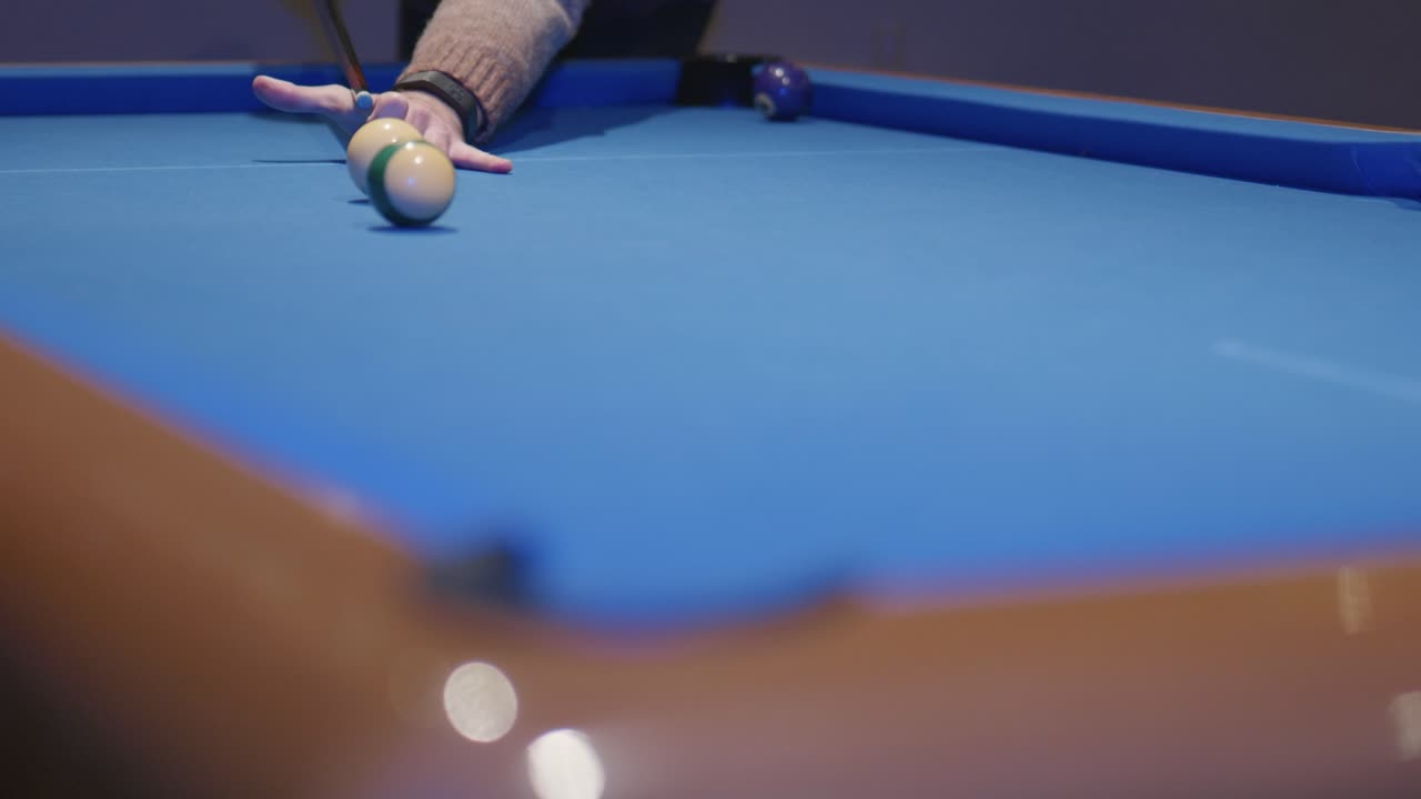 A slow motion snooker player potting ball