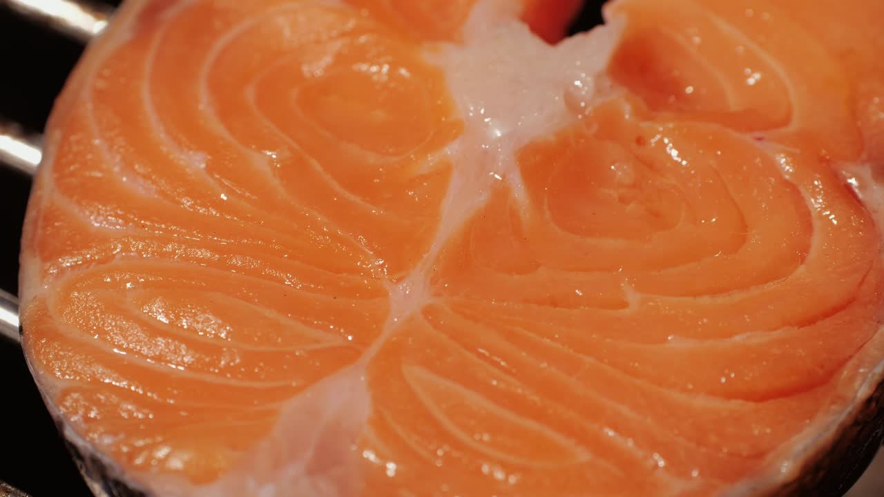 Chef che cucina bistecche di salmone rosso con olio e spezie sulla griglia in primo piano. Gamberi sul fuoco, poi saltati in padella. Preparazione di orate sulla griglia rovente. Concetto di cibo da ristorante. Barbecue di frutti di mare