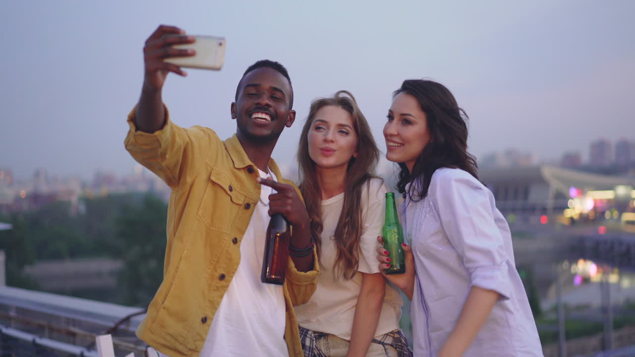 Friends taking a selfie on a rooftop at night