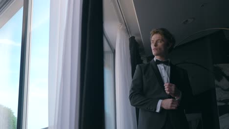 man in tuxedo getting ready in hotel room