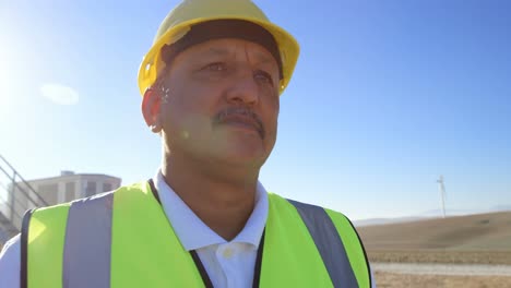 Male-engineer-standing-in-the-wind-farm-4k