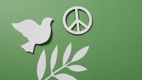 primer plano de una paloma blanca con un signo de paz y una hoja y un espacio de copia en fondo verde