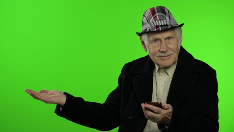 elderly grandfather man using smartphone, pointing at something with hand