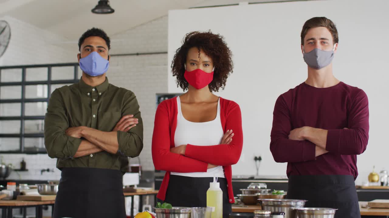 Diverse group of chefs wearing masks in kitchen