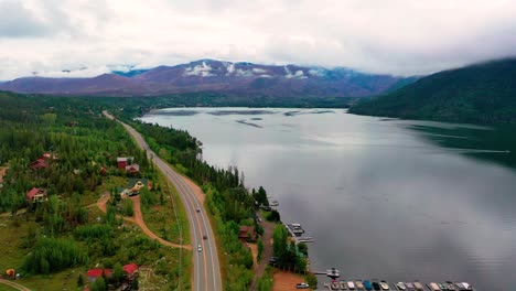 Impresionante-Lago-De-Montaña-Con-Coches-Circulando-Por-La-Autopista-A-Lo-Largo-De-La-Costa.