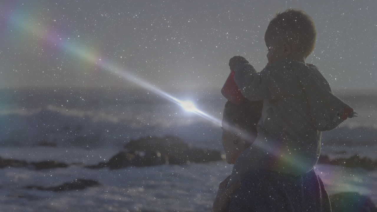 At beach, child on adult's shoulders with sparkling animation effects