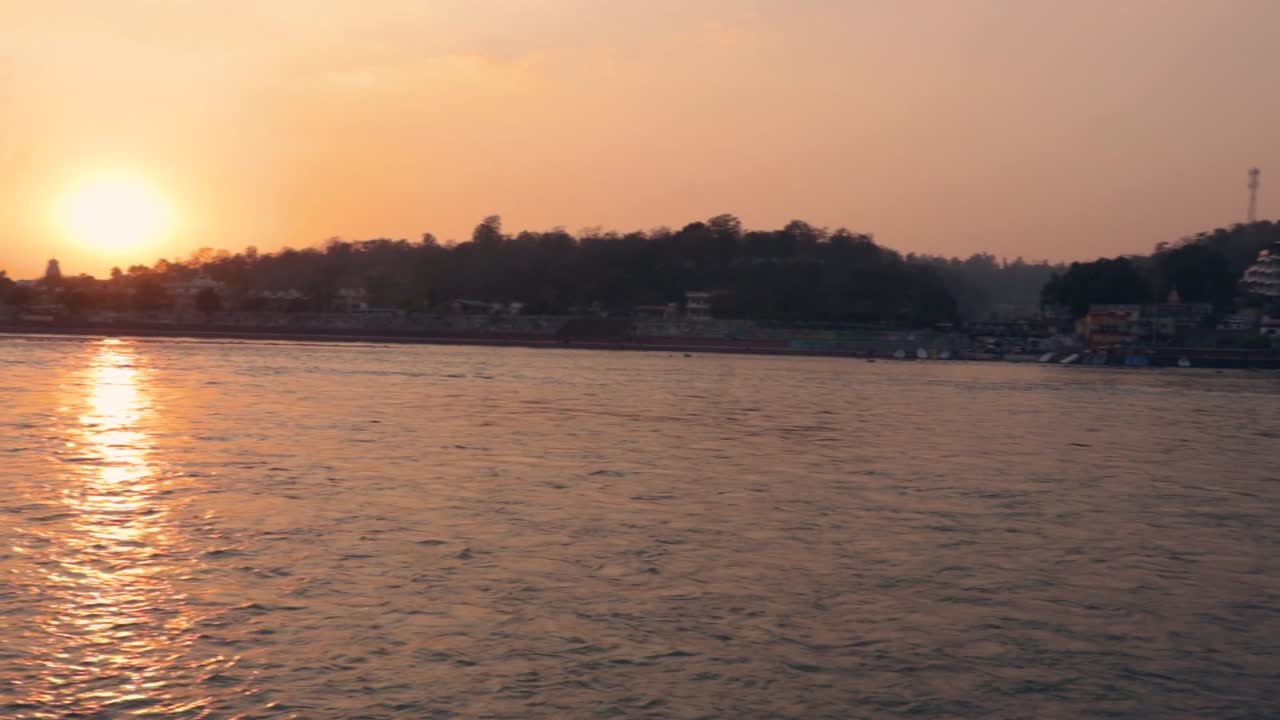 el cielo naranja de la puesta de sol sobre el horizonte fluvial del río al atardecer desde un video de ángulo plano se toma en rishikesh uttrakhand india el 15 de marzo de 2022
