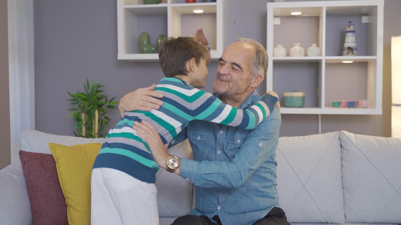 Grandson kisses grandfather's hand.