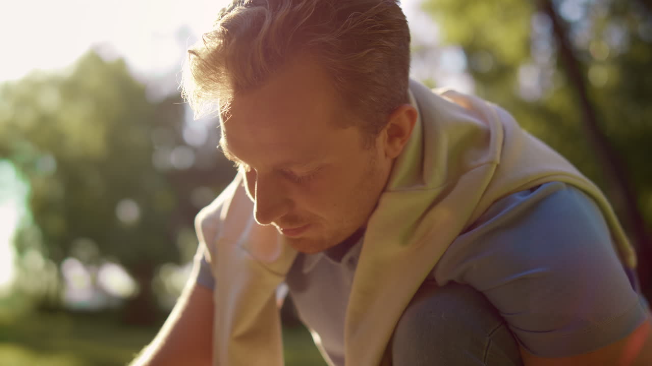 클로즈업 매력적인 남자가 앉아서 아래를 바라보고 있습니다. 손 패들 작동