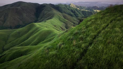 aerial forward shot of mount labawan green grassland scenery ridge trail