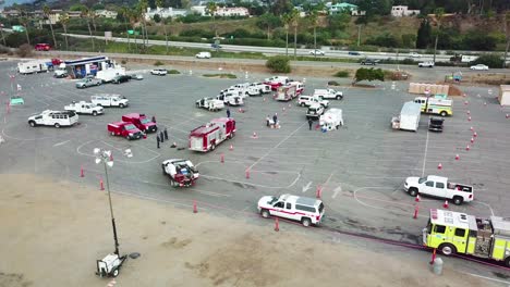 high angle pan of firefighters in fire trucks lining up for duty at a staging area during the thomas fire in ventura california in 2017