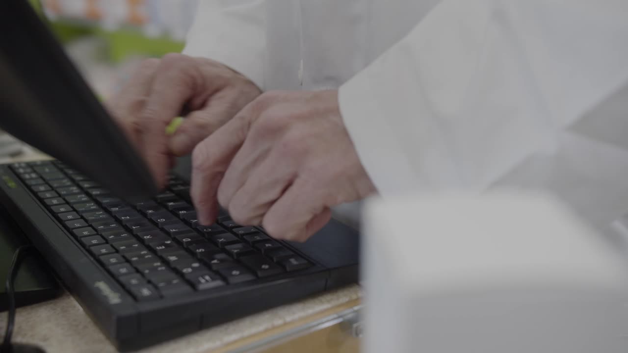 farmacéutico con bata blanca escribe algo en