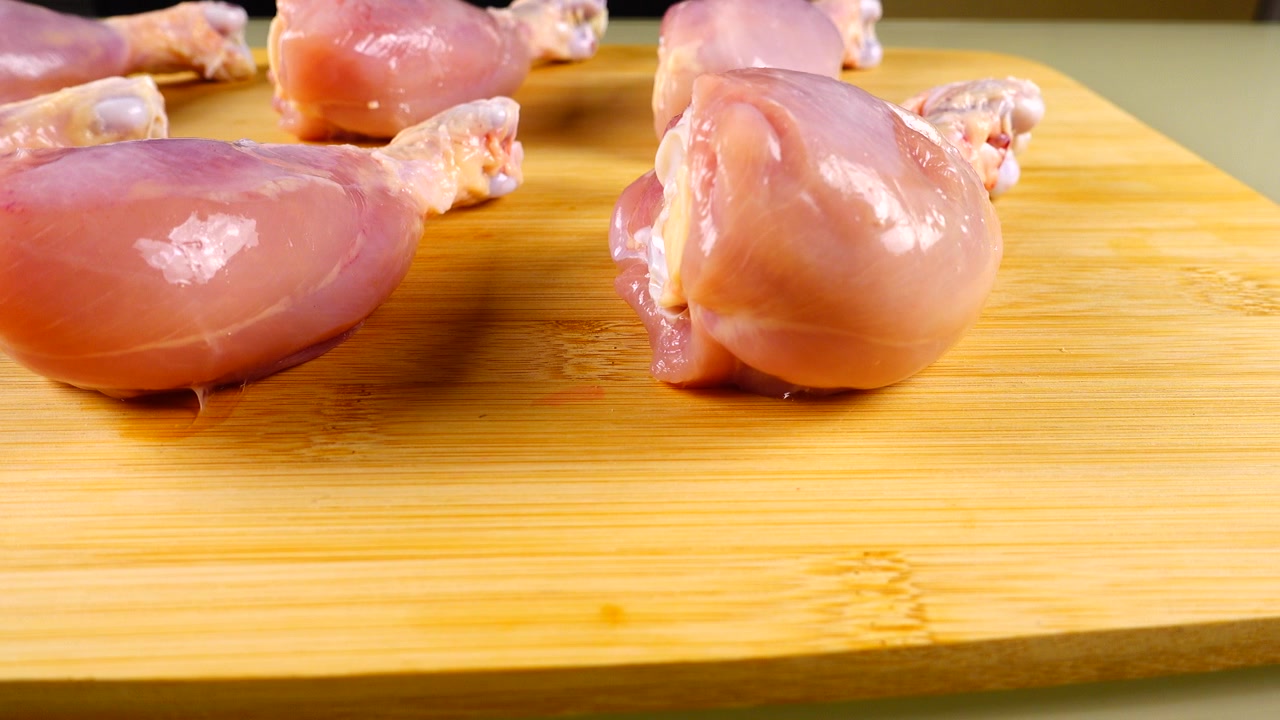 Cosce di pollo fresche su un tagliere