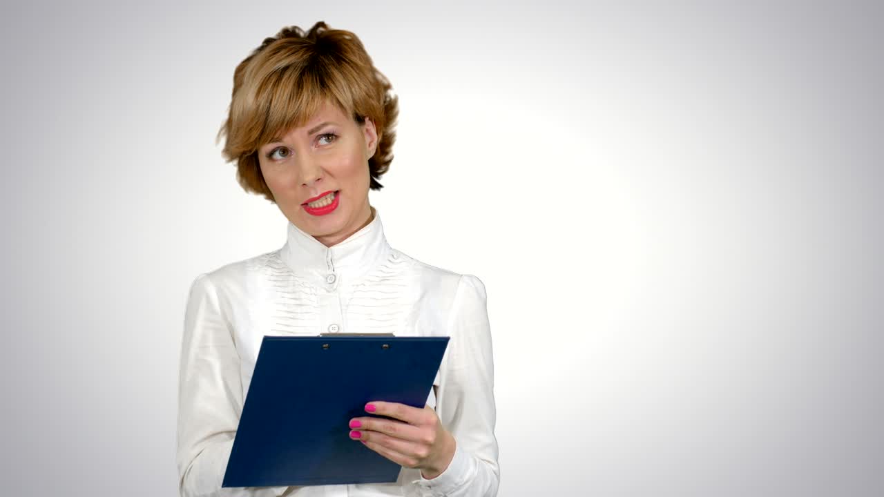 Joven y hermosa mujer de negocios con traje, sonriendo, feliz, trabajando con una tablet, escribiendo un mensaje sobre fondo blanco