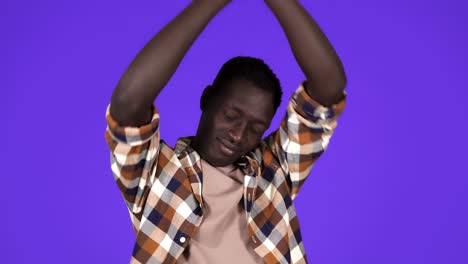 A-short-haired-young-african-american-man-is-yawning,-touching-his-face,-tired-and-sleepy-standing-isolated-over-blue-wall-background-in-studio