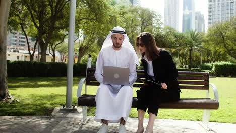 Man-and-woman-sitting-on-the-bench-of-a-park