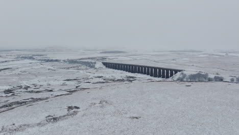 Weitwinkelaufnahme-Einer-Luftdrohnenaufnahme-Des-Ribblehead-Viadukts-An-Einem-Verschneiten-Und-Düsteren-Tag-In-Yorkshire-Dales,-Großbritannien