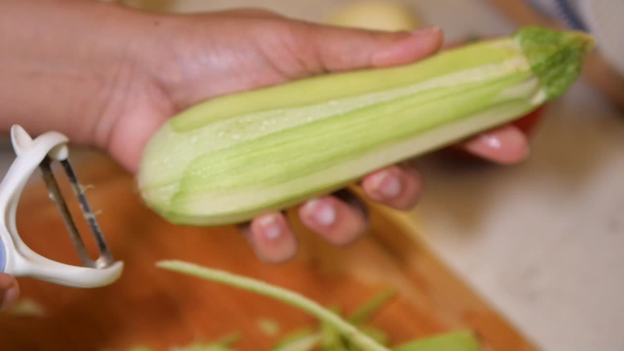 Peeling zucchini with a peeler
