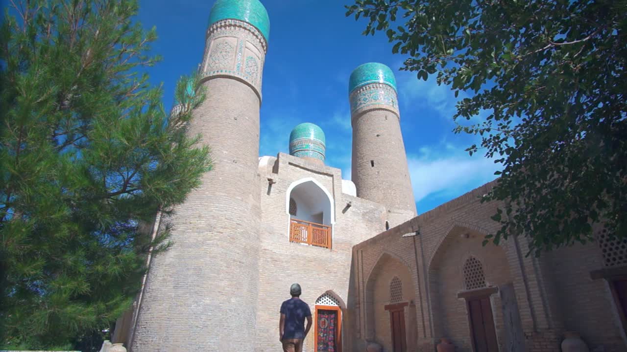 A male backpacker visiting Chor Minor in Bukhara, Uzbekistan.