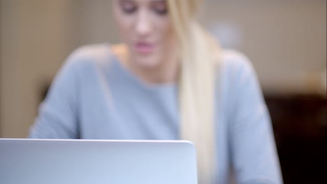 Smiling-young-woman-working-on-a-laptop