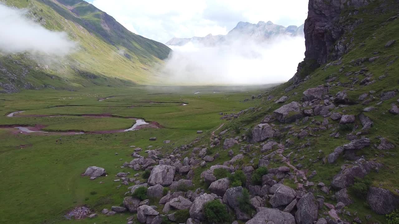 스페인 피레네 산맥, 스페인 - 강바닥과 움직이는 구름이 있는 발레 데 아구아스 투에르타스 계곡의 공중 무인 항공기 전망