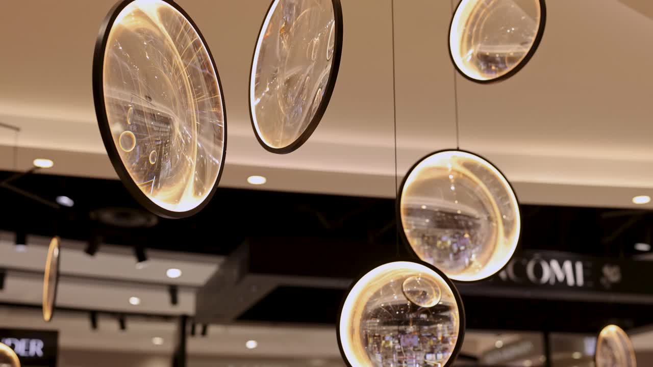 Glass ornaments suspended in a well-lit duty-free shop, reflecting ambient light and creating a serene atmosphere