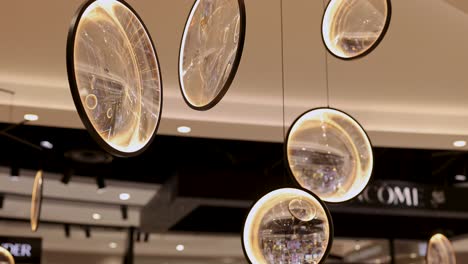 glass ornaments suspended in a well-lit duty-free shop, reflecting ambient light and creating a serene atmosphere