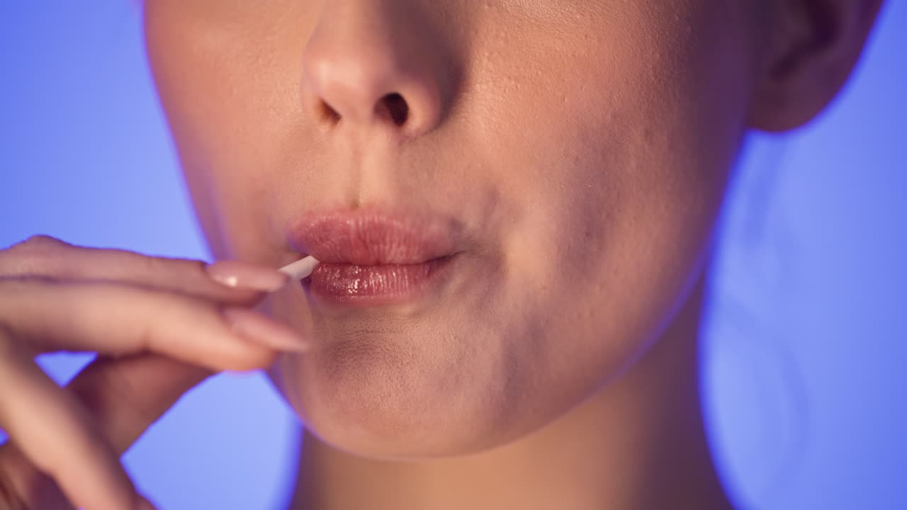 mujer lamiendo una piruleta, estudio de cerca