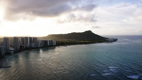 drone shot of oahu's calm waters surrounding diamond head at sunset