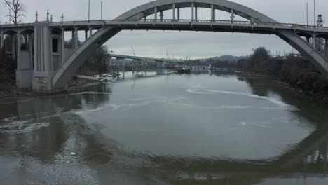 aerial shot over willamette river under arch bridge in oregon city