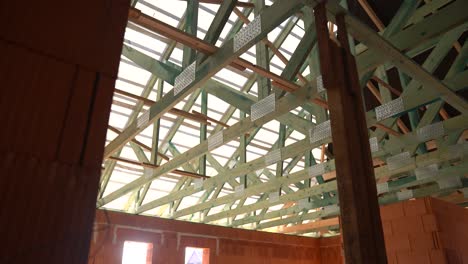 interior view of new house under construction with brick walls and roof trusses and battens