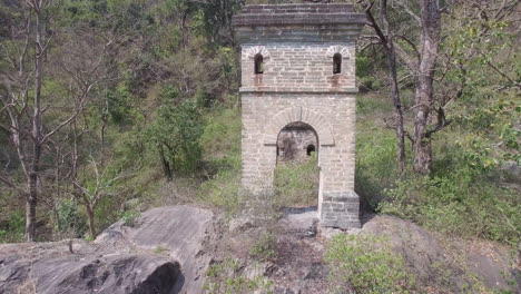 Old-stone-ruins-hidden-in-the-forest-of-Rishikesh,-India,-pan-shot