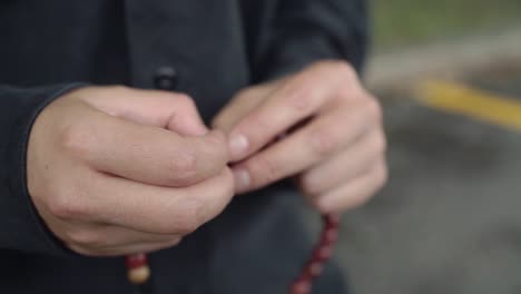 a woman counts beads on a rosary