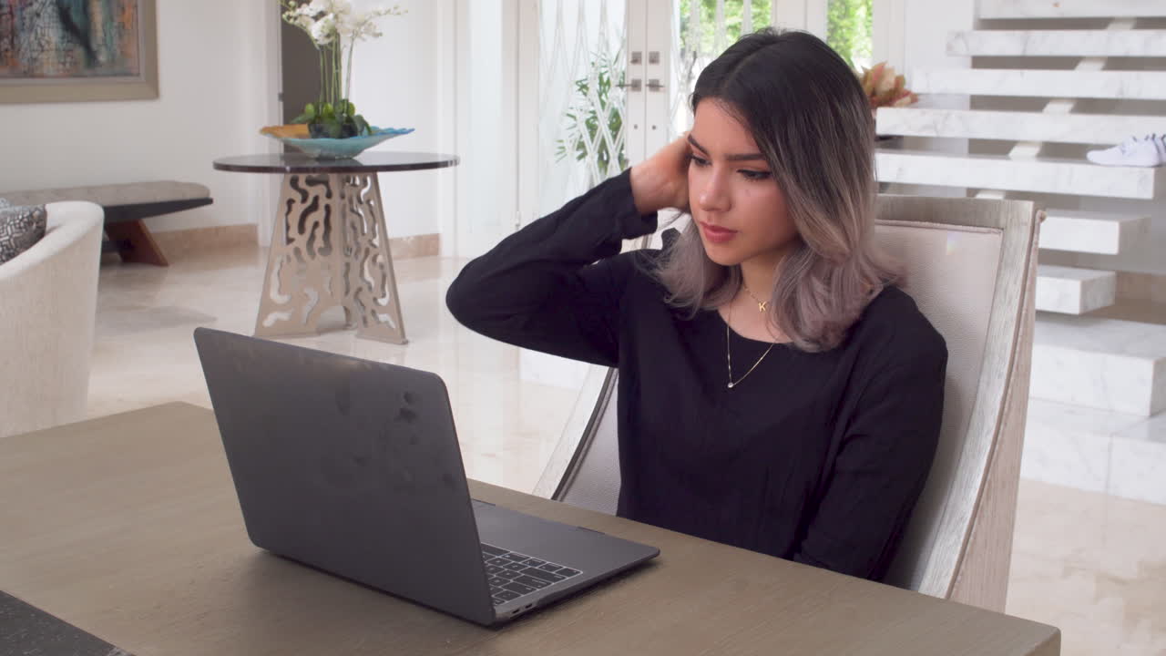Young beautiful female talking on internet using laptop, handheld view