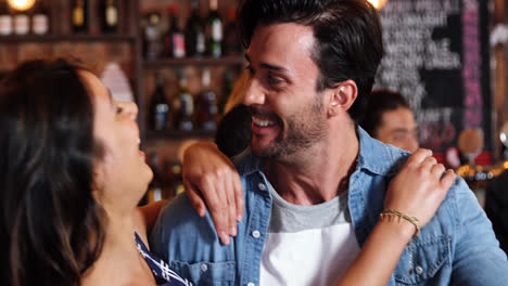 una pareja interactuando en un pub.