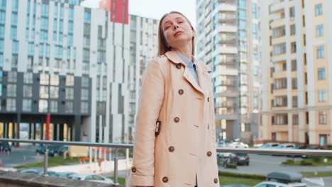 portrait of happy blonde mature woman turning and looking at camera standing arms crossed on street