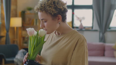 girl with prosthetic arm smelling fresh flowers
