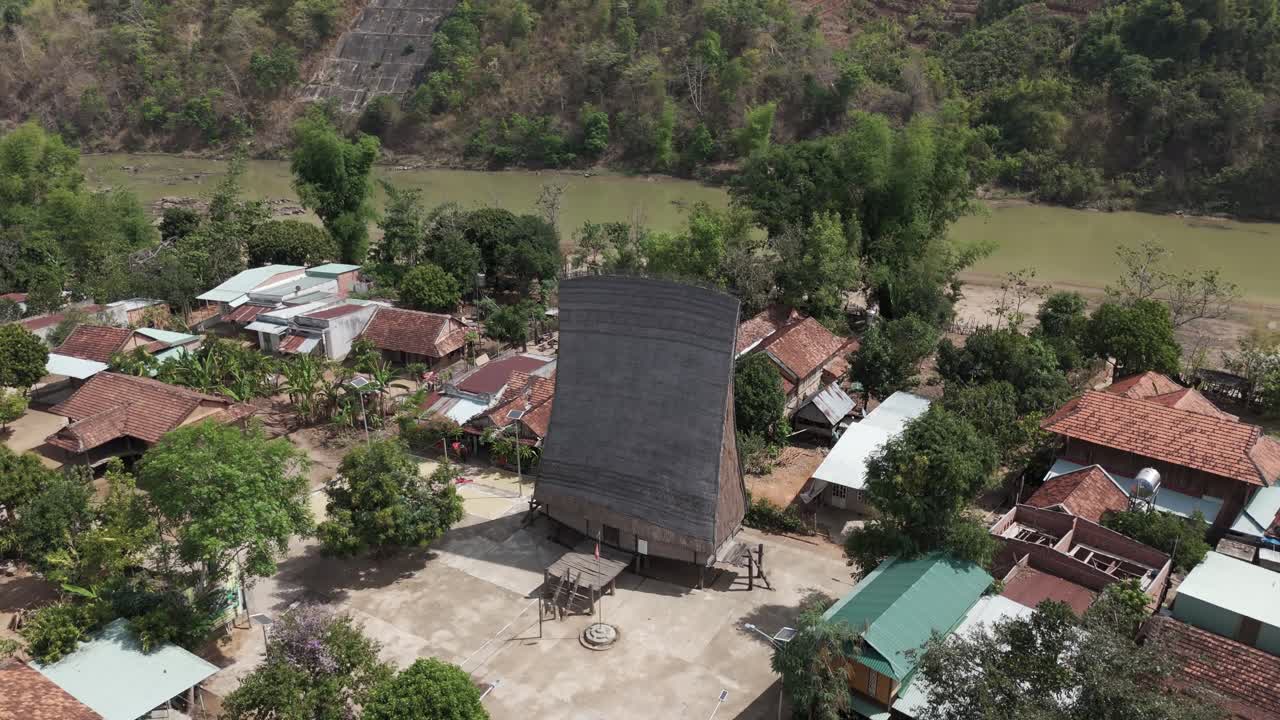 Aerial drone footage above a Bahnar village and the traditional wooden community house in Kon Tum province, Vietnam 1-2