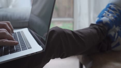 Man has slippers on while working on computer from his home