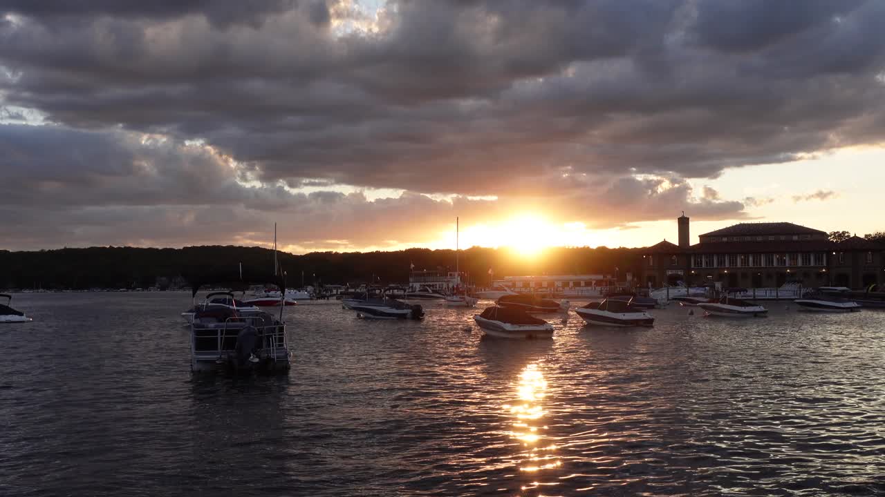 Dramatic sunset with boats on the water, cloudy evening