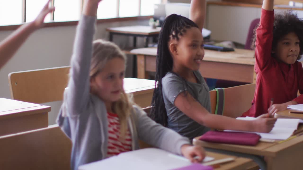 grupo de niños levantando las manos en la clase en la escuela