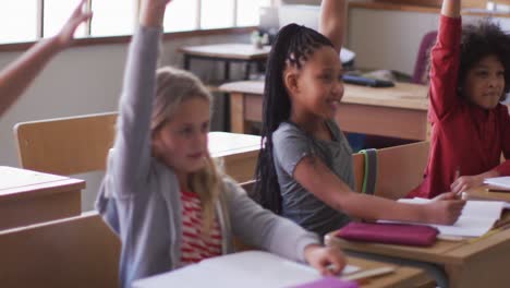 group of kids raising their hands in the class at school