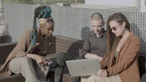 business people looking at laptop screen during outdoor party