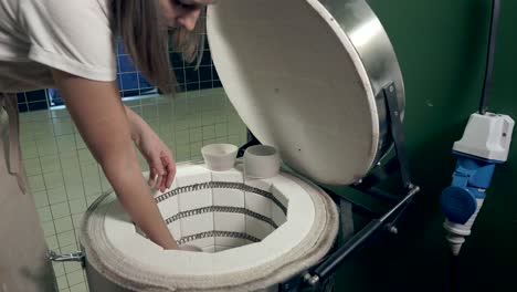 mujer trabajando con un horno en un estudio de cerámica