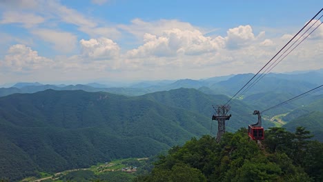 daedunsan cable car gondola moving above a mountain range national park, south korea - static shot